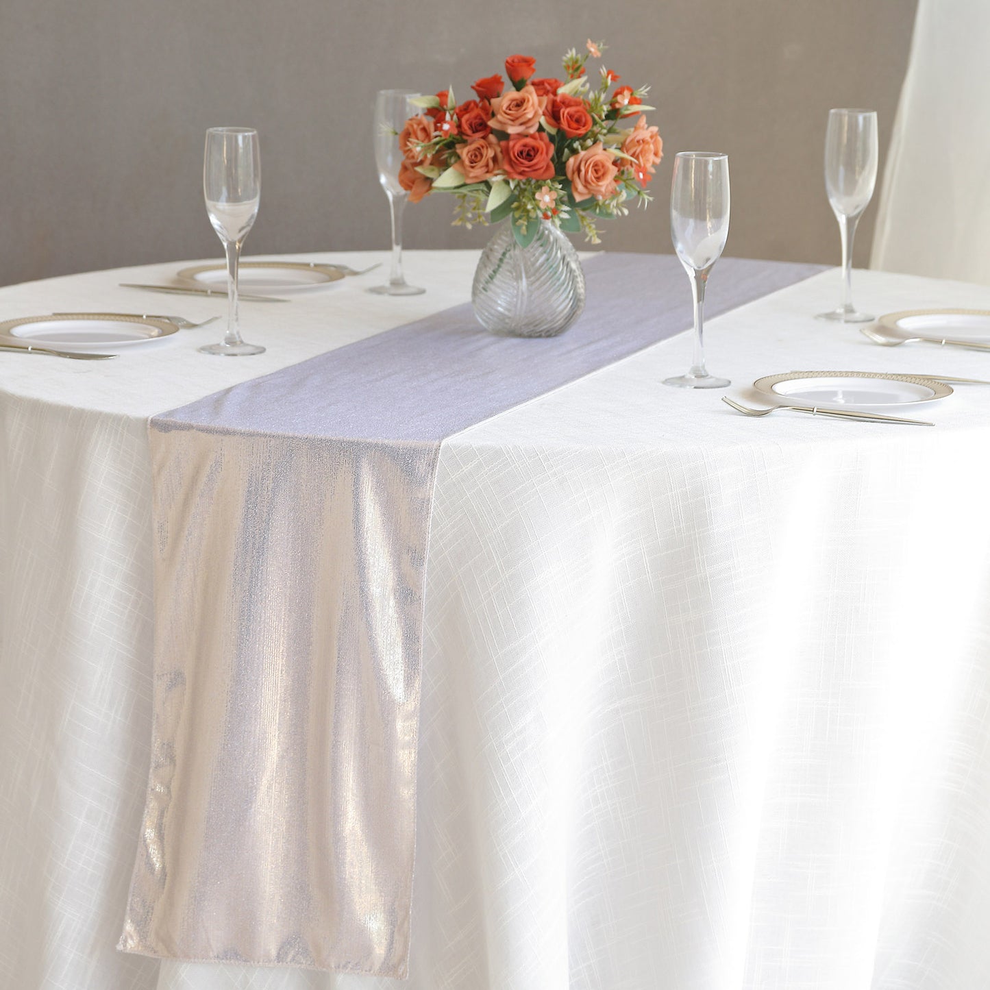 Beige shimmer sequin table runner on a white table with floral centerpiece.