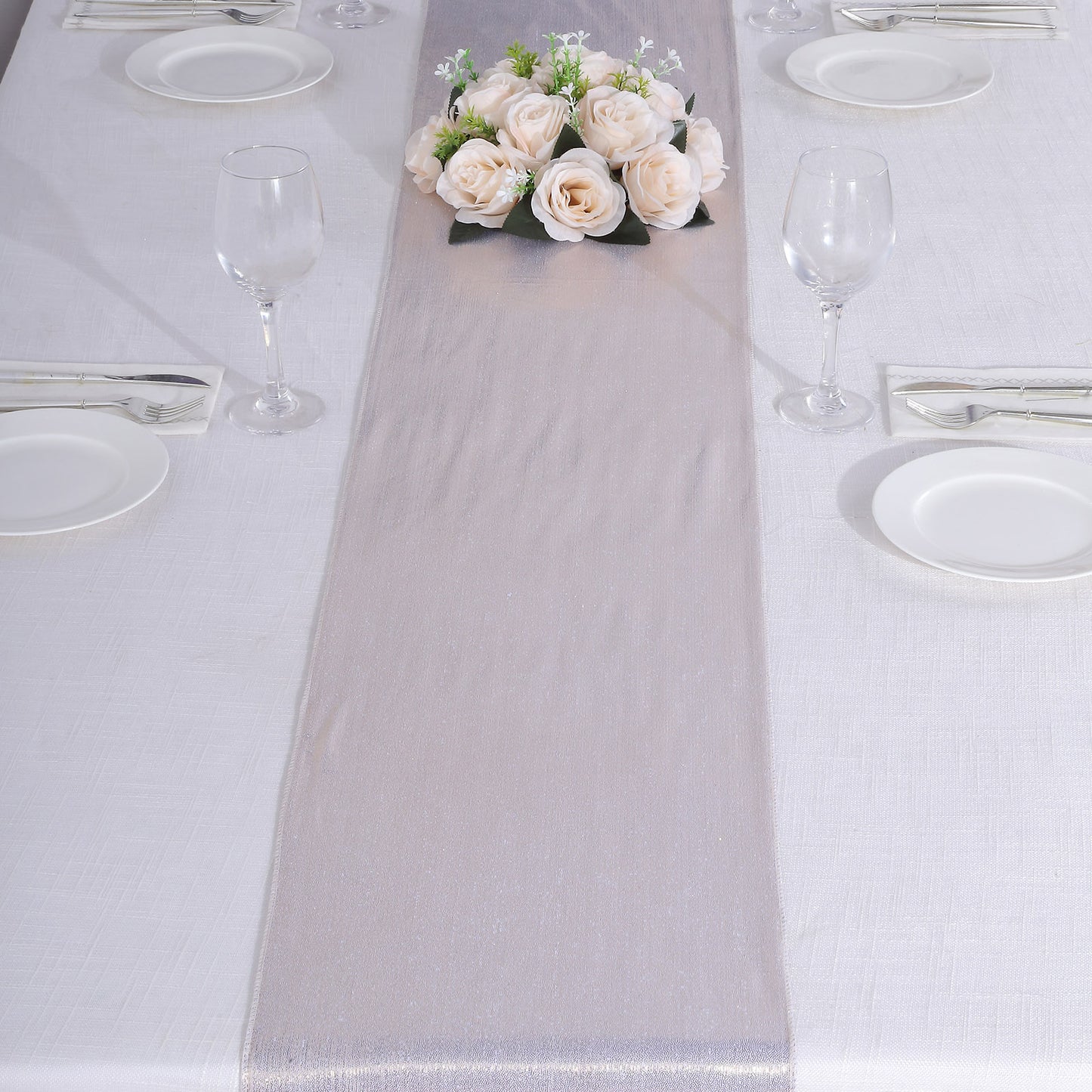 Beige shimmer sequin table runner with floral centerpiece on a dining table.