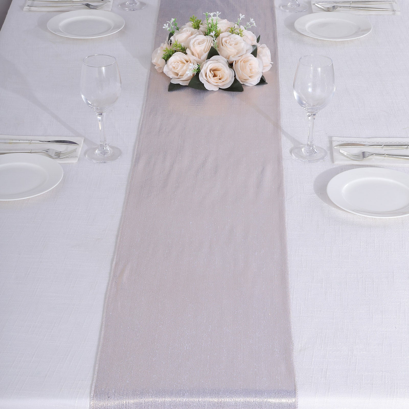 Beige shimmer sequin table runner with floral centerpiece on a dining table.