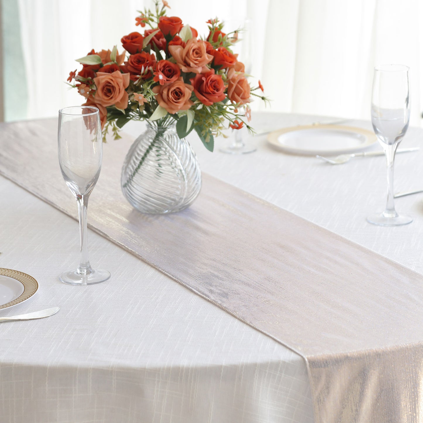 Beige shimmer sequin dots table runner on a white table with flowers.