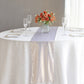Beige shimmer sequin table runner on a round table with floral centerpiece.