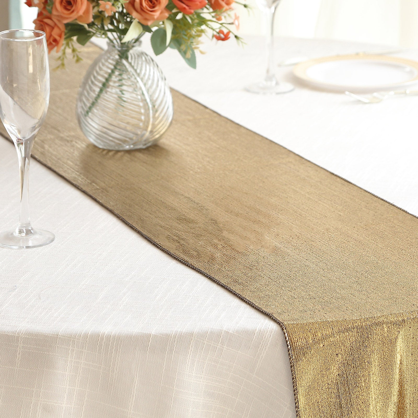 Antique gold shimmer sequin table runner on a white tablecloth.