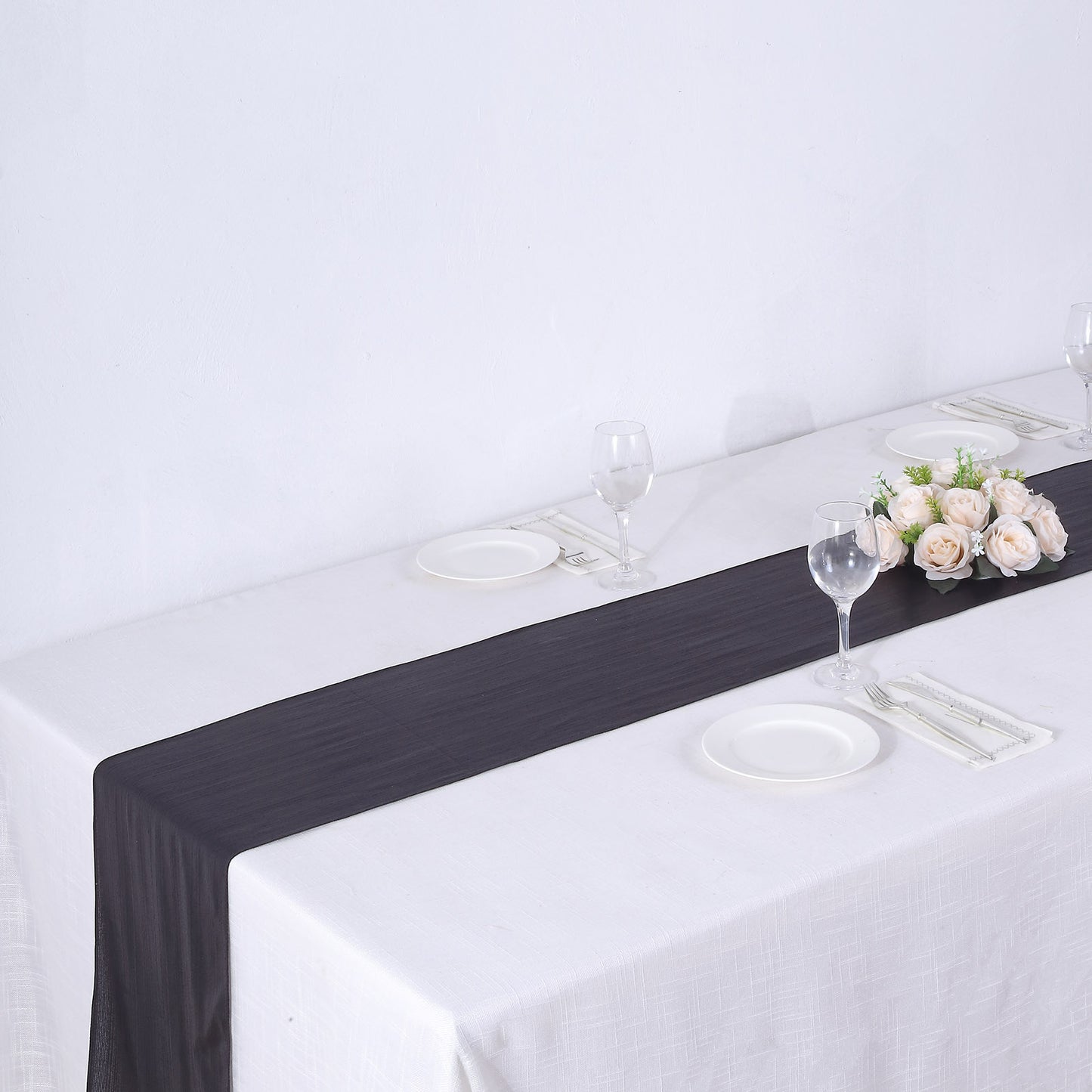 Black shimmer sequin table runner on a white table setting.