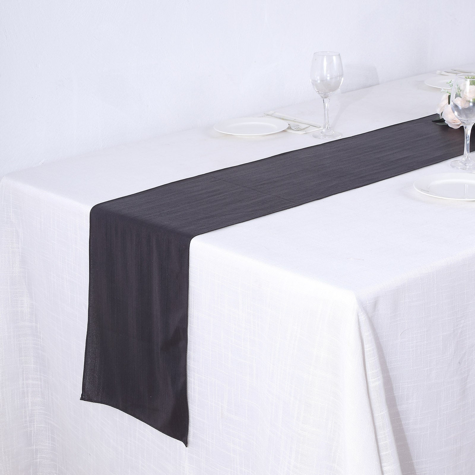 Black table runner with shimmer sequin dots on a white table.