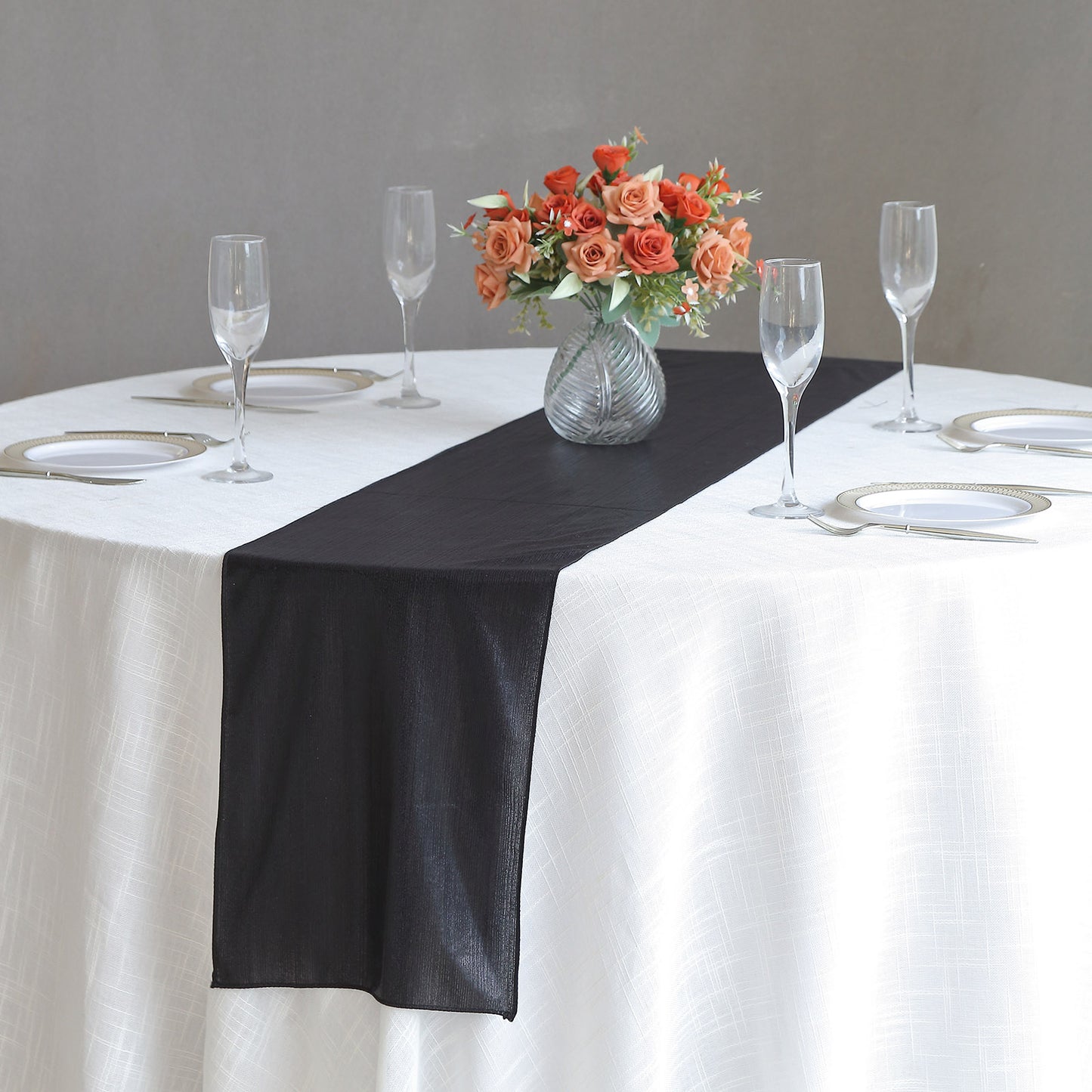 Black shimmer sequin table runner on a round white table.