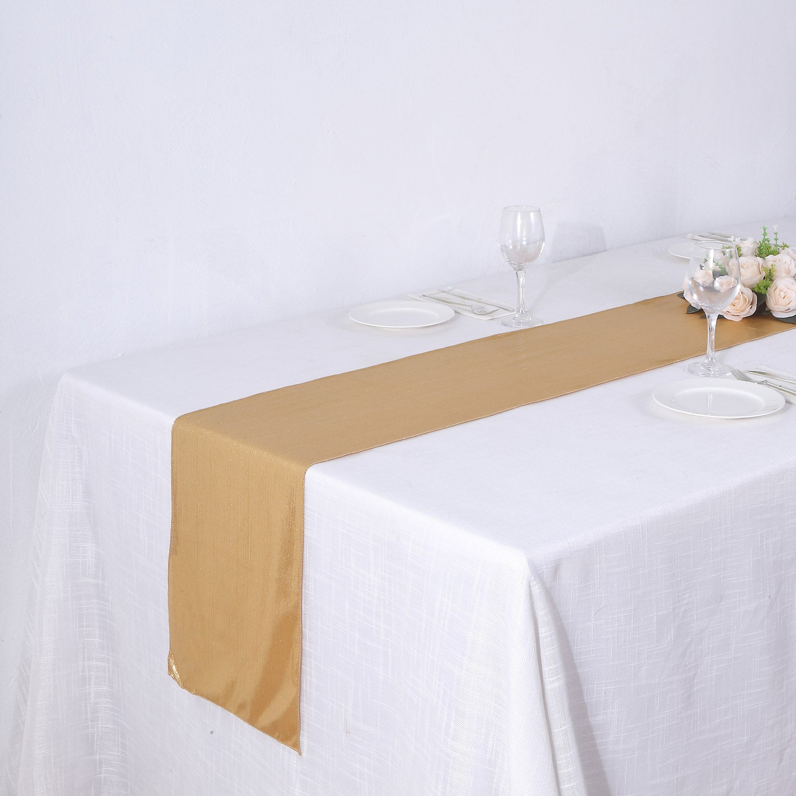 Gold shimmer sequin dots table runner on a white tablecloth.