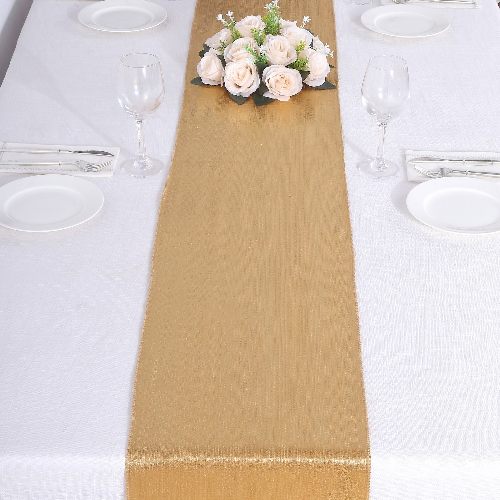 Gold shimmer sequin table runner on a white table setting.