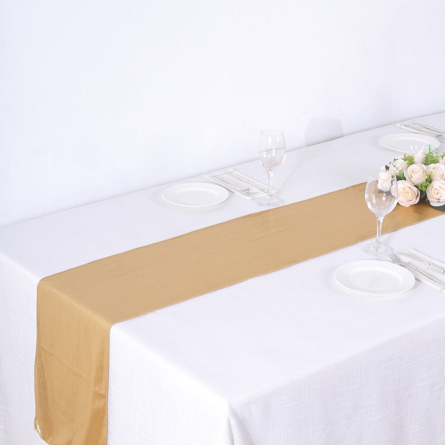 Gold shimmer sequin dots table runner on a white table setting.