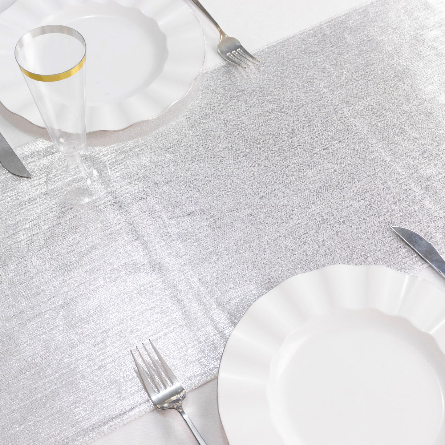 Silver shimmer sequin dots table runner on a white table setting.