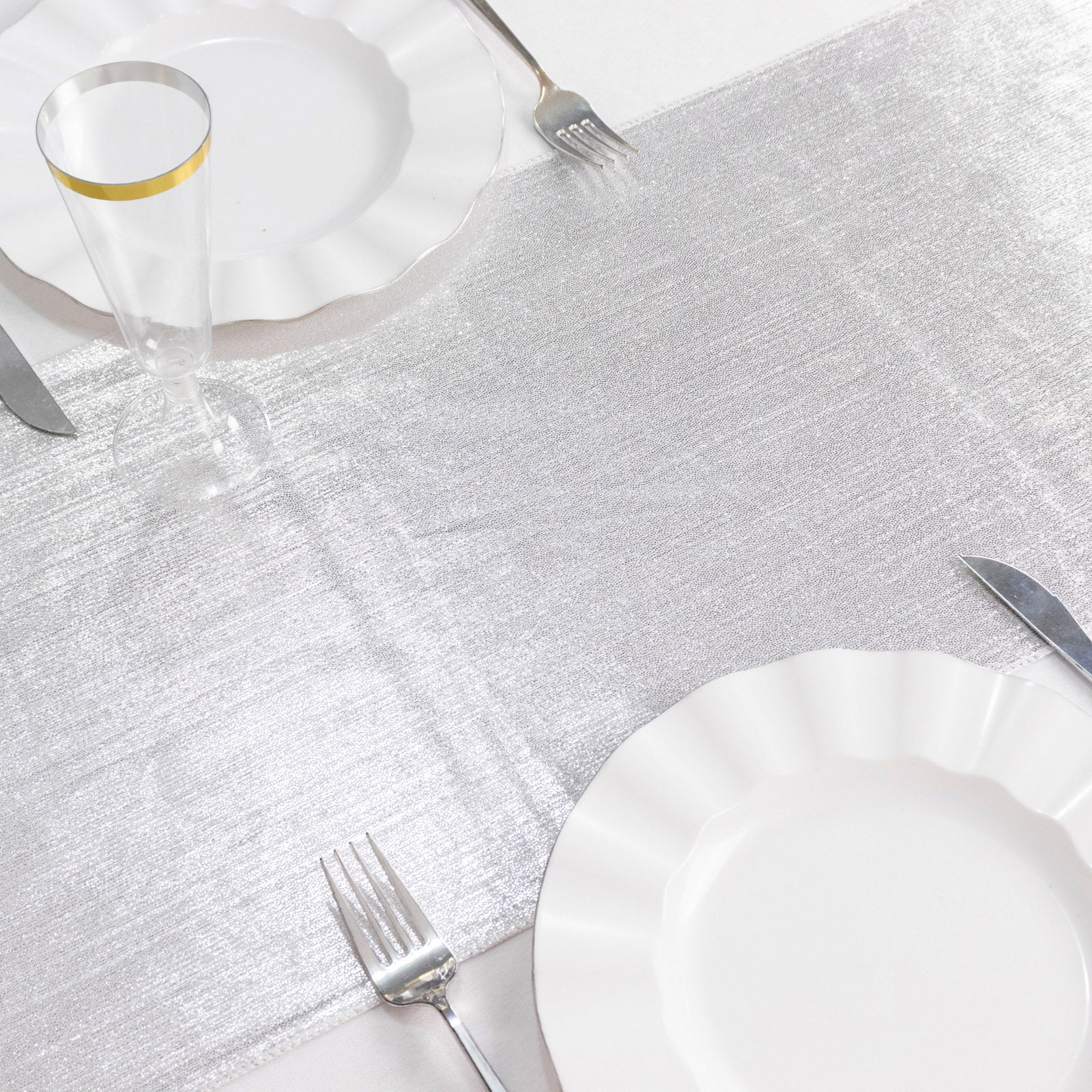 Silver shimmer sequin dots table runner on a white table setting.