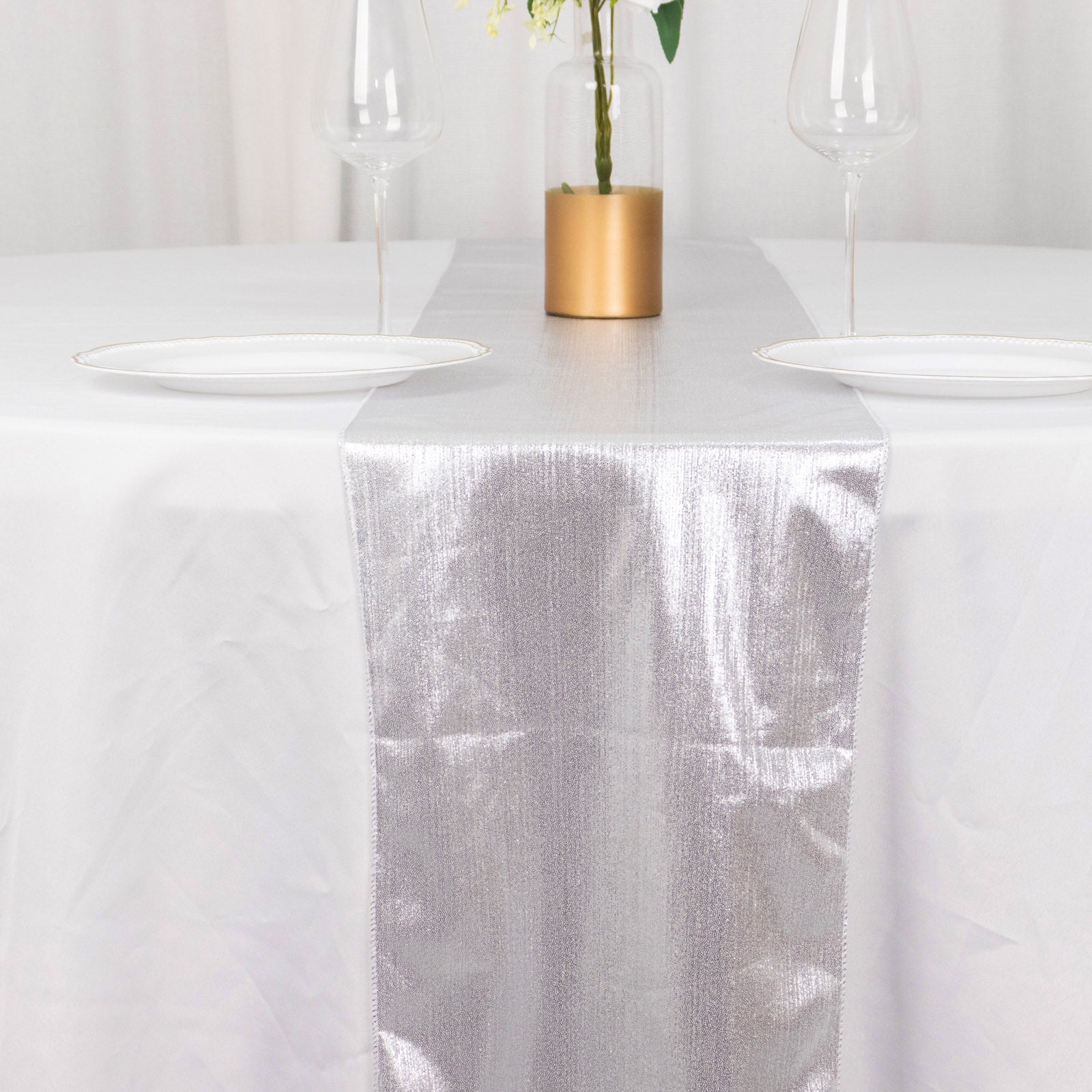 Silver shimmer sequin dots table runner on a white table.