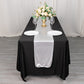 Silver shimmer sequin dots table runner on a black table with floral centerpiece.