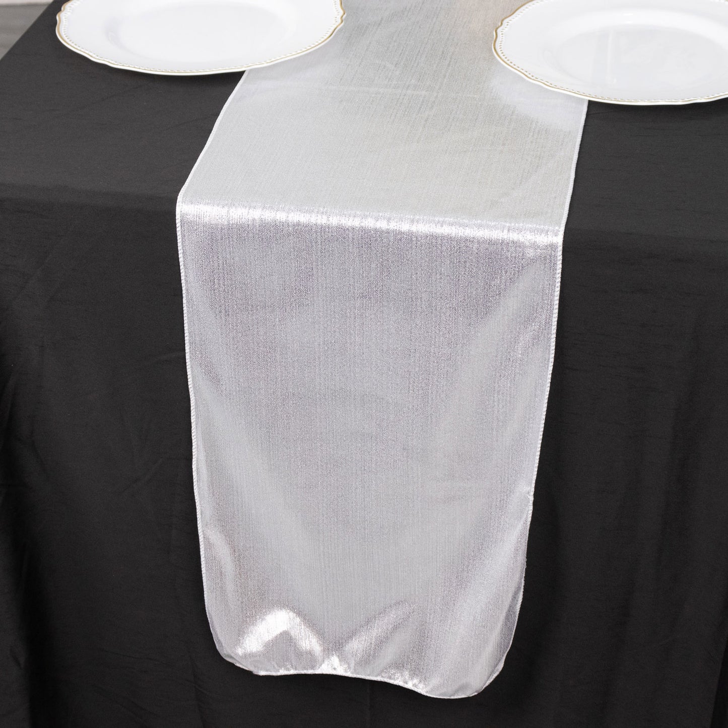 Silver shimmer sequin dots table runner on a black tablecloth.