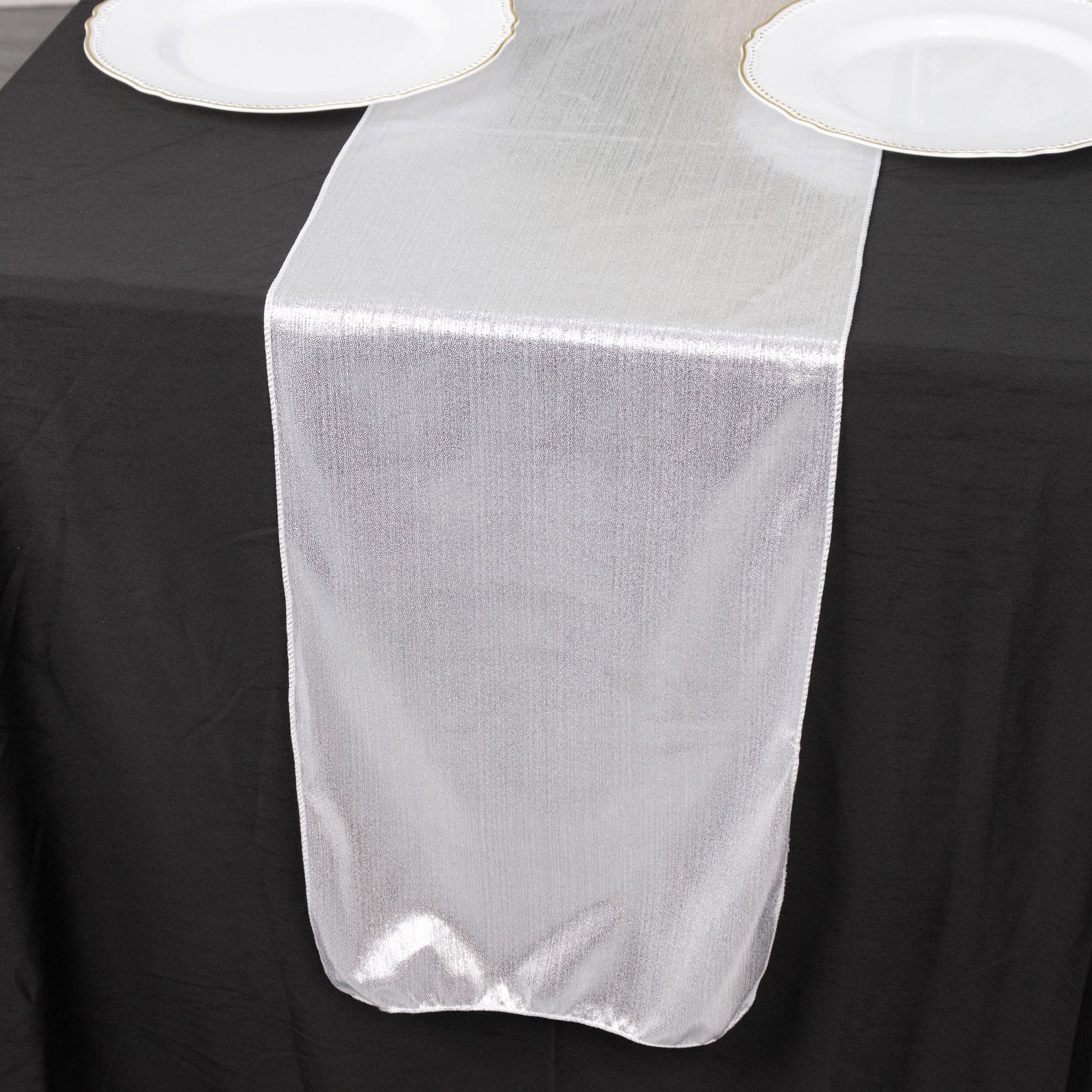 Silver shimmer sequin dots table runner on a black tablecloth.