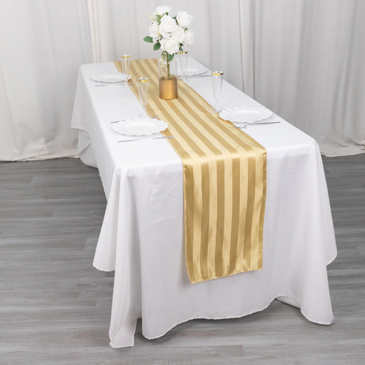 Champagne satin stripe table runner on a white tablecloth.