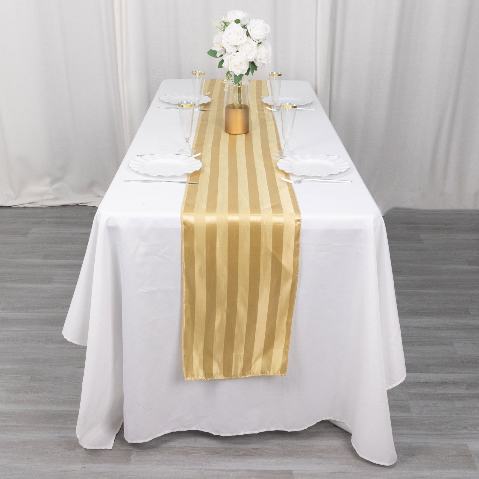 Champagne satin stripe table runner on a white table setting.