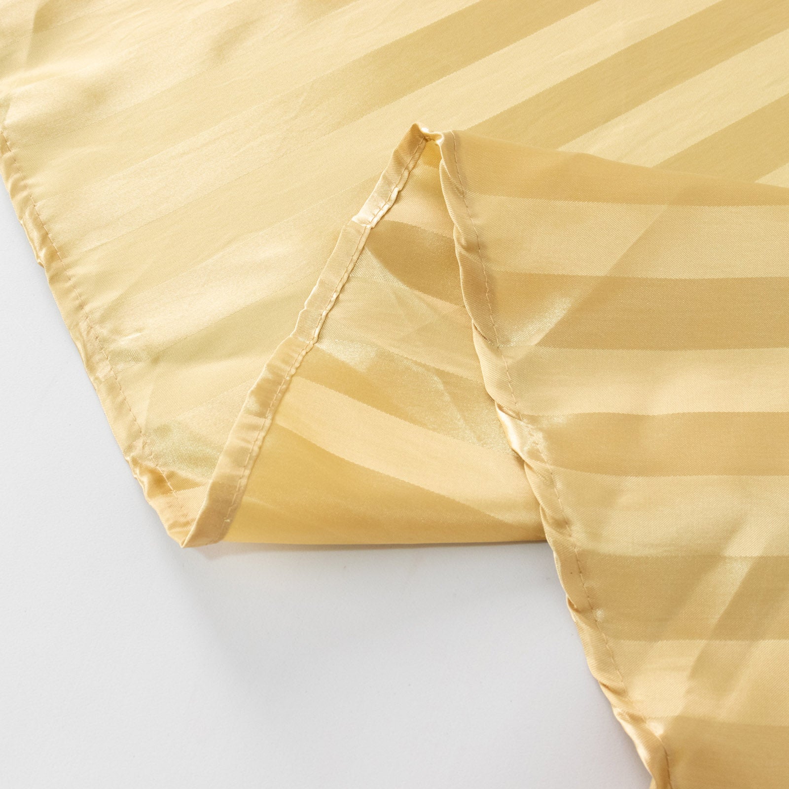 Champagne satin stripe table runner for elegant table settings.
