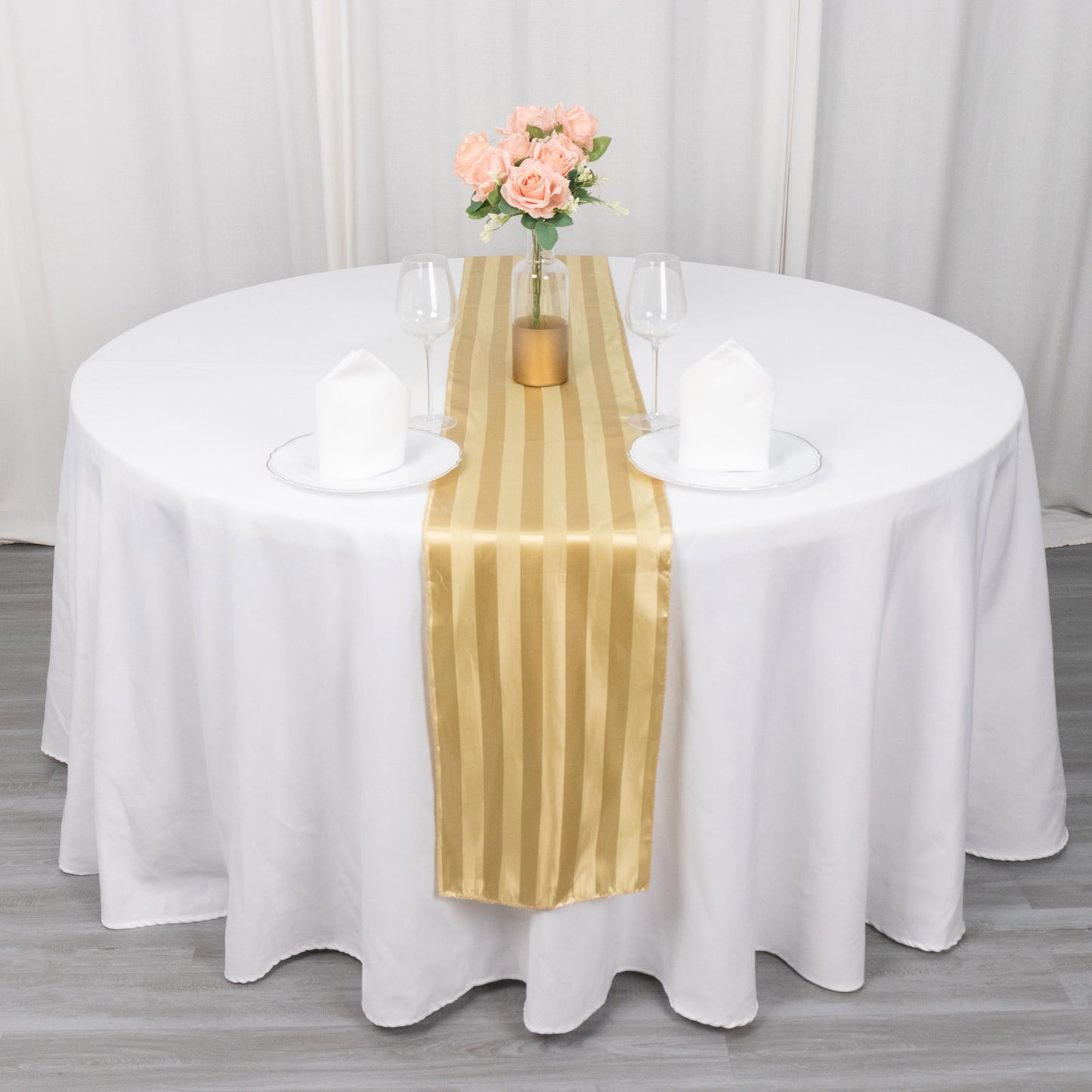 Champagne satin stripe table runner on a round table with floral centerpiece.