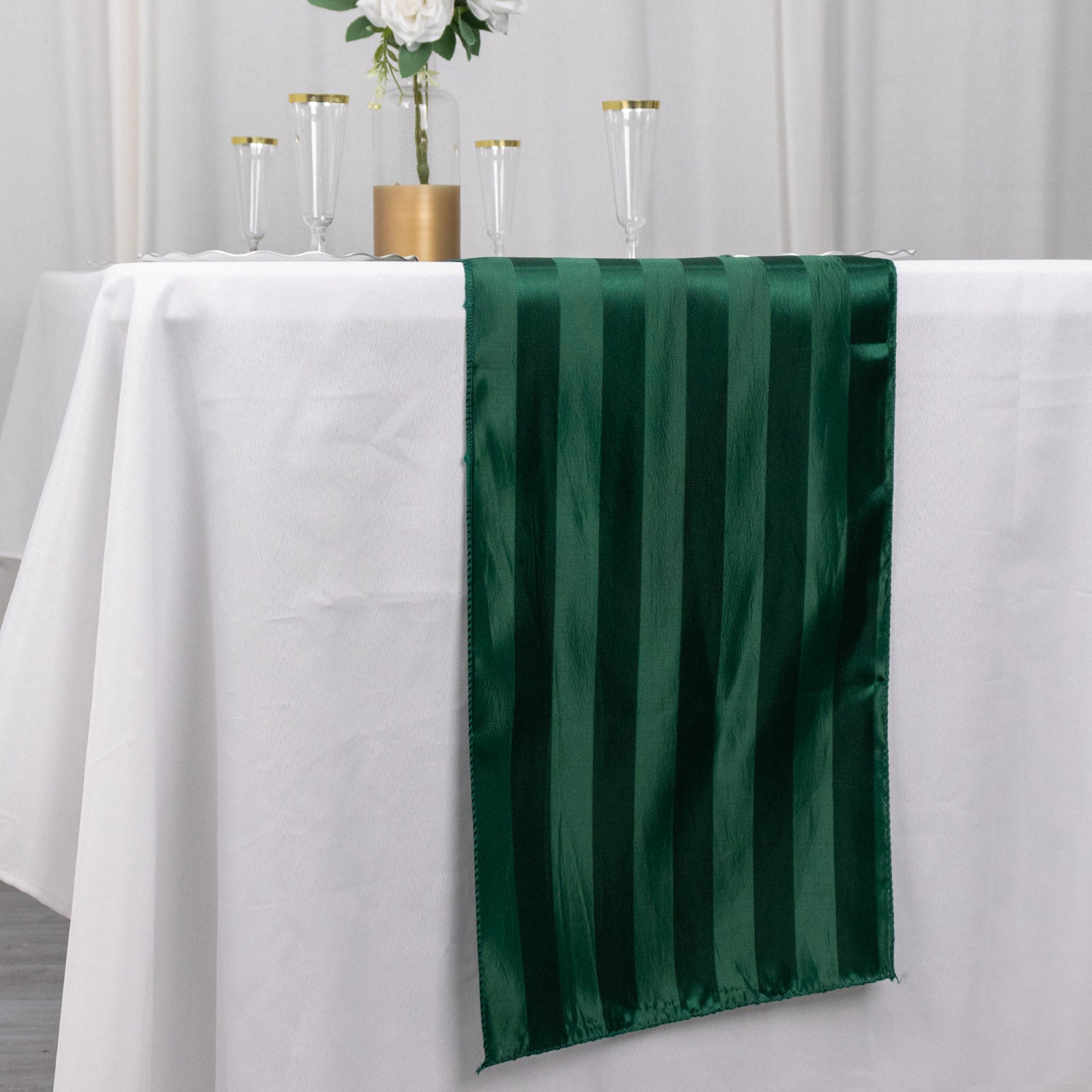 Hunter emerald green satin stripe table runner on a white table.