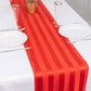 Red satin stripe table runner on a white table.