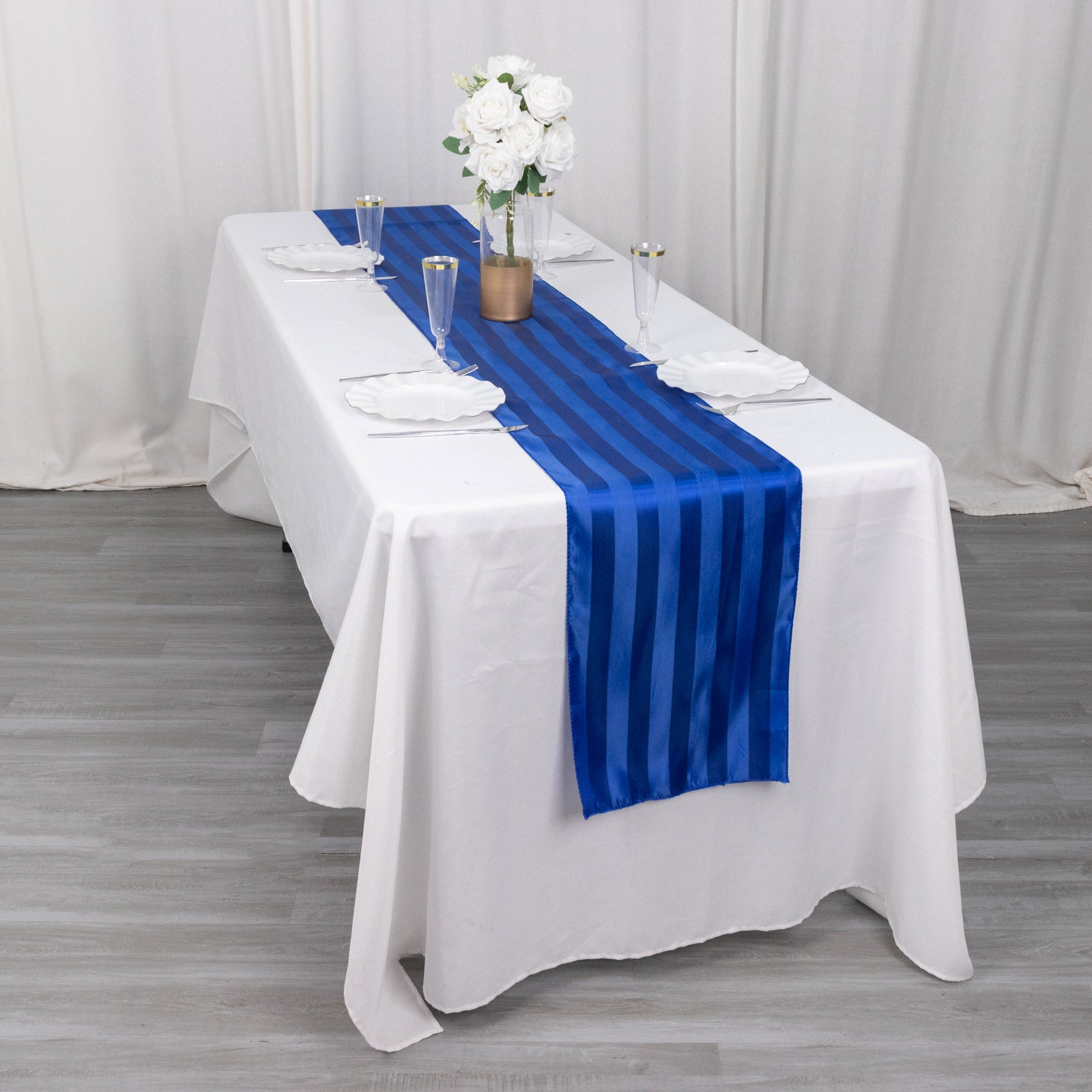 Royal blue satin stripe table runner on a white table.