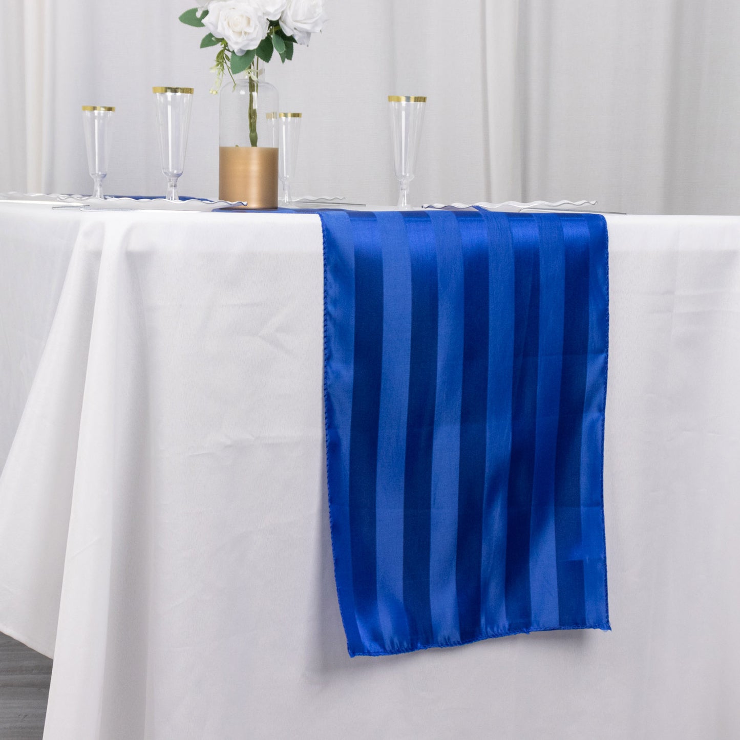 12"x108" Royal Blue Satin Stripe Table Runner on a white table.