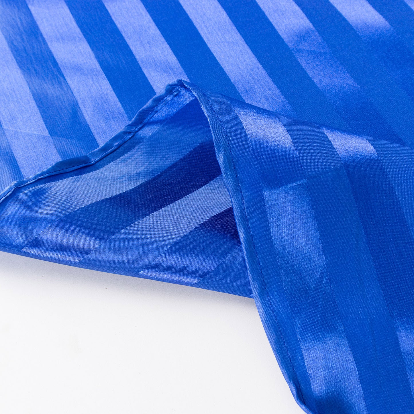 Royal blue satin stripe table runner elegantly draping.