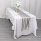 Silver satin stripe table runner on a white table with floral decor.