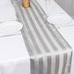 12"x108" silver satin stripe table runner on a white table.