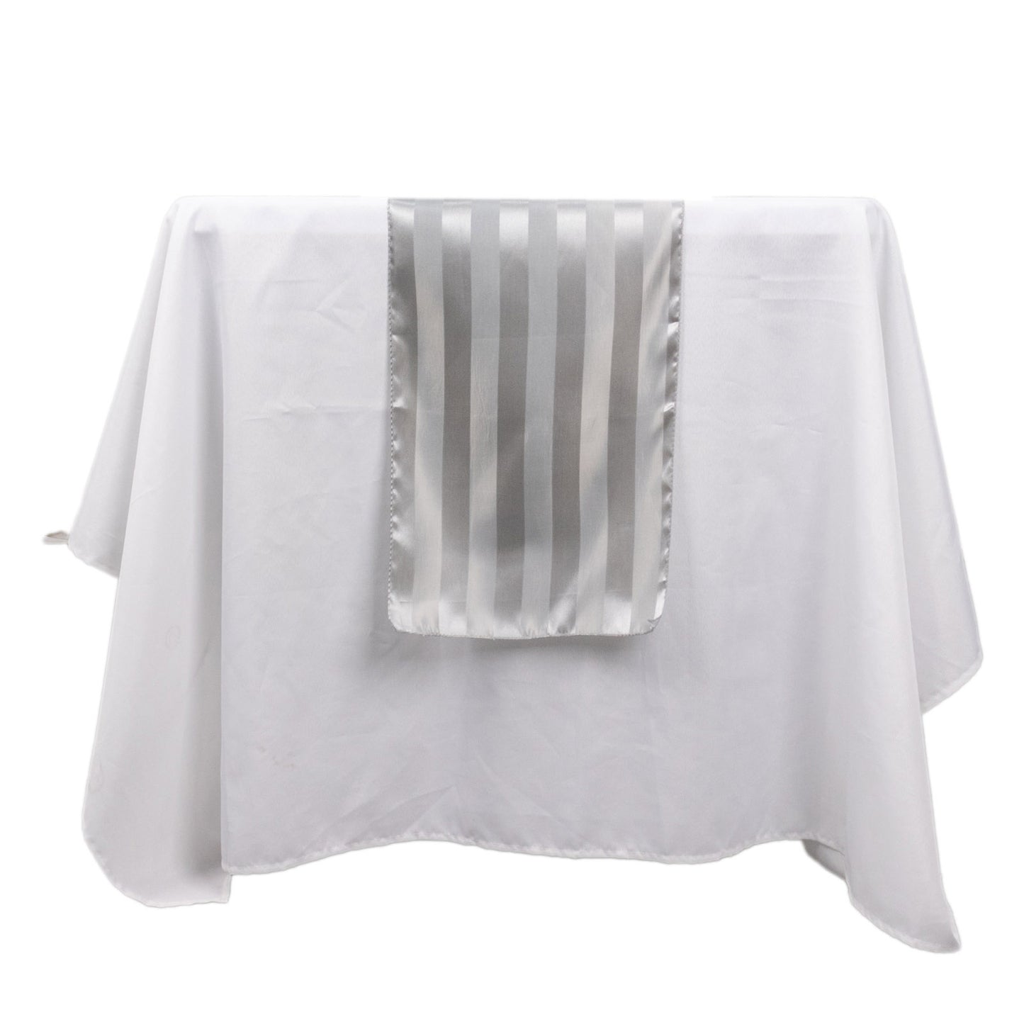 Silver satin stripe table runner on a white tablecloth.