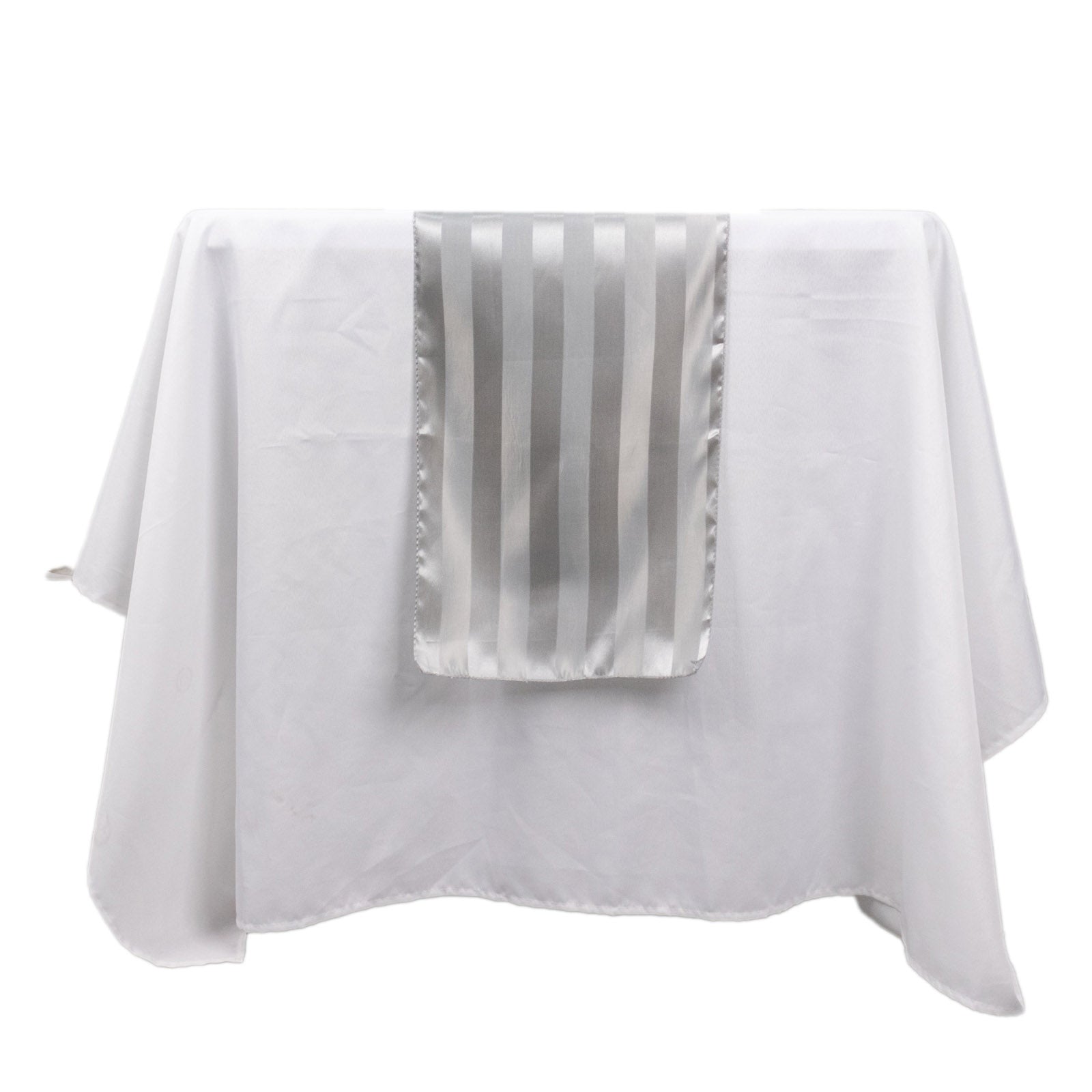 Silver satin stripe table runner on a white tablecloth.