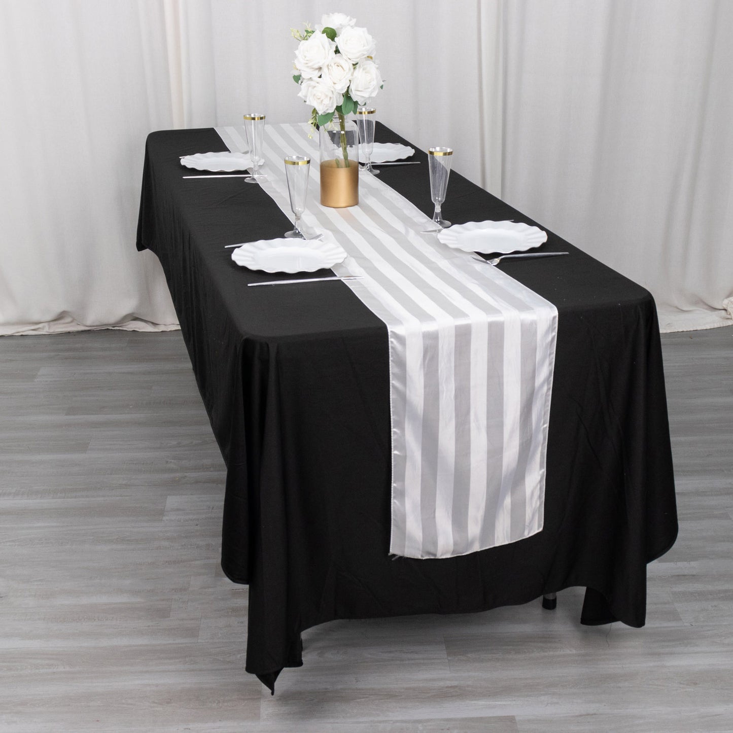 White satin stripe table runner on a black tablecloth.