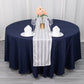 White satin stripe table runner on a dark blue tablecloth.