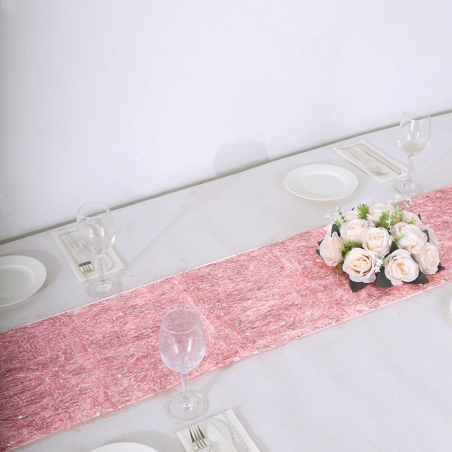 Rose gold metallic fringe tinsel table runner on a dining table.