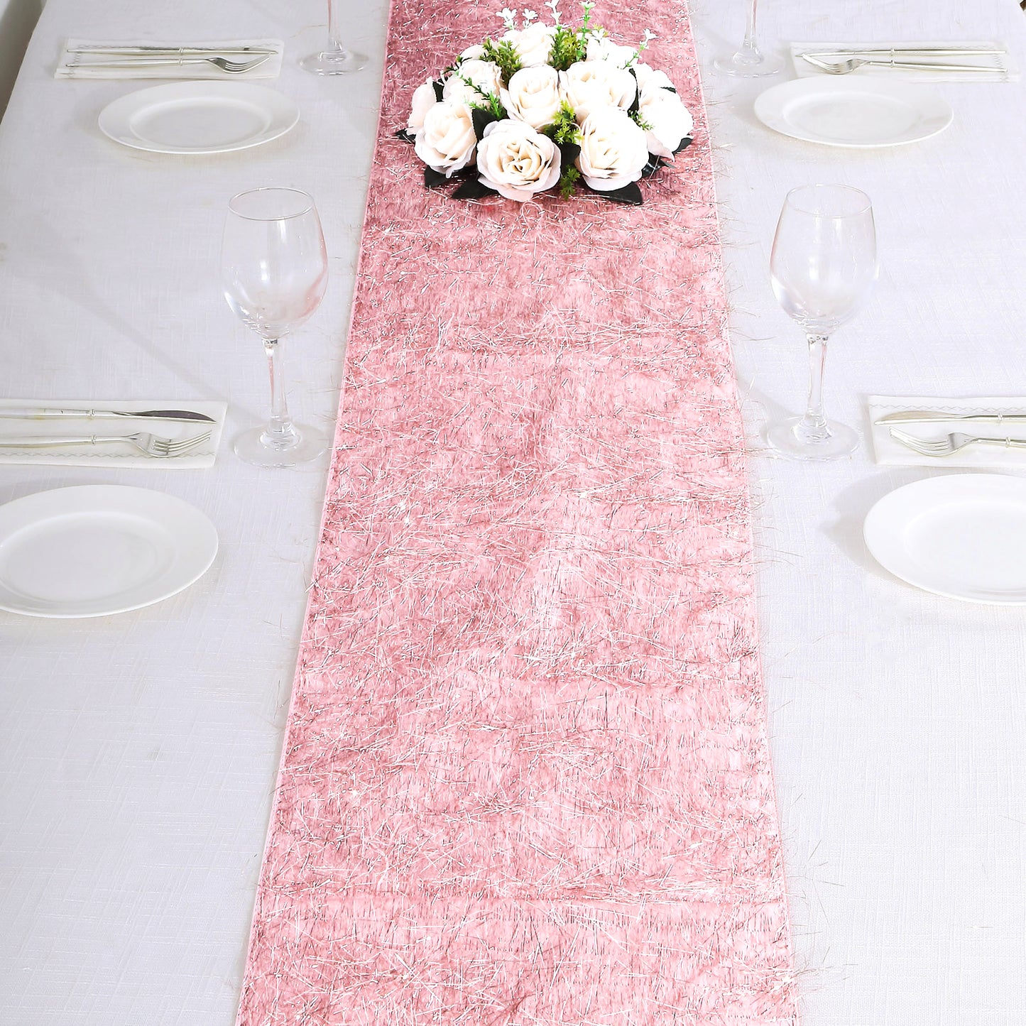 Rose gold metallic fringe tinsel table runner on a dining table.