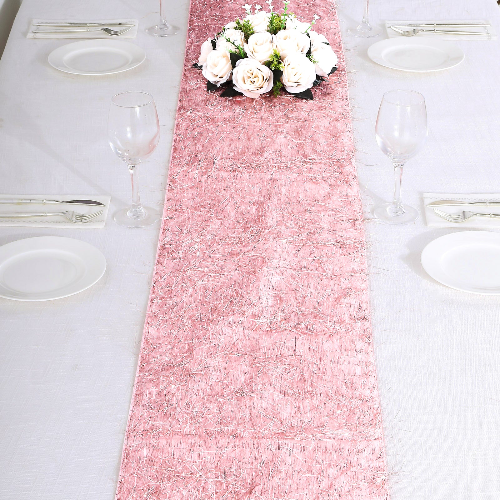 Rose gold metallic fringe tinsel table runner on a dining table.