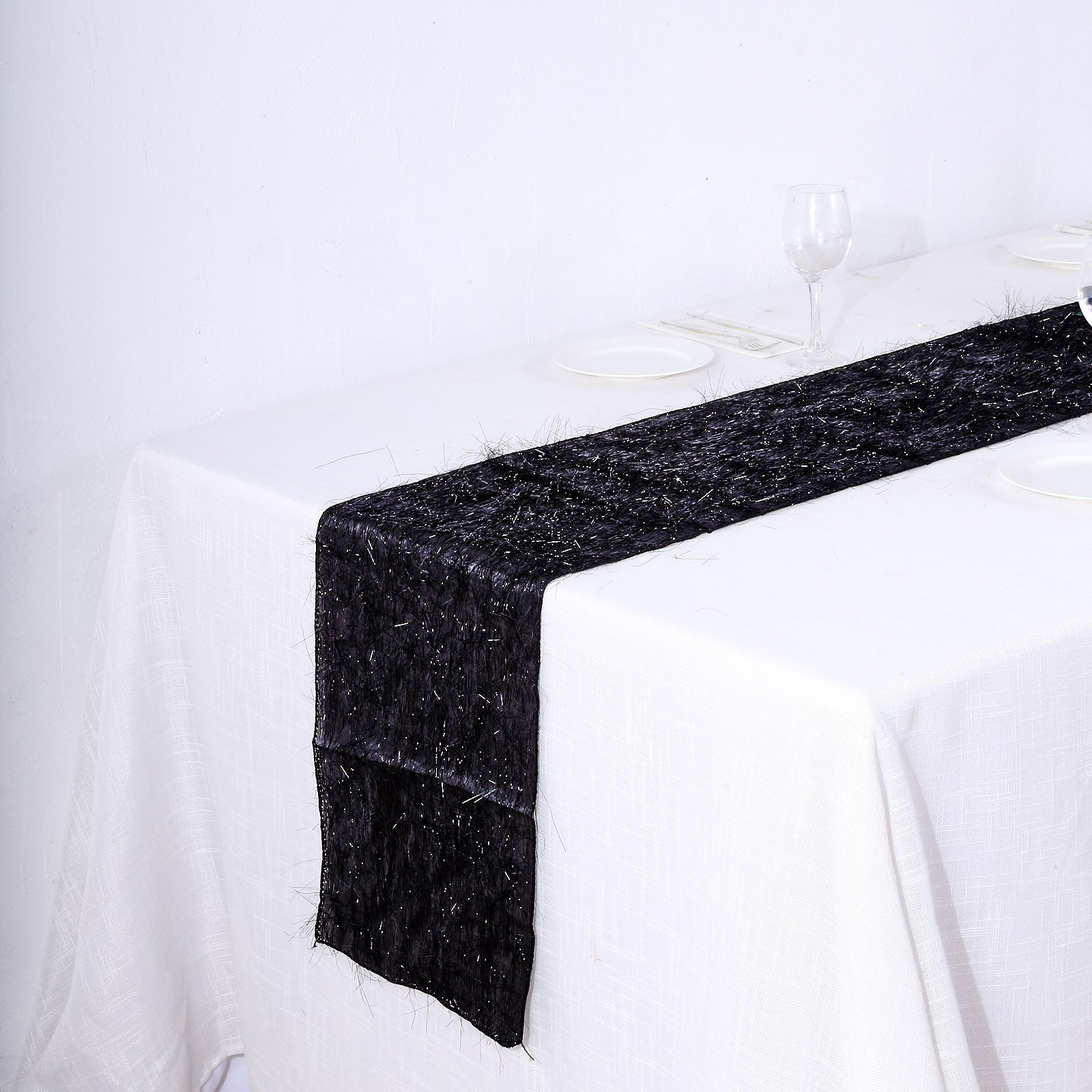 Black metallic fringe shag tinsel table runner on a white table.