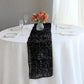 Black metallic fringe tinsel table runner on a white table.