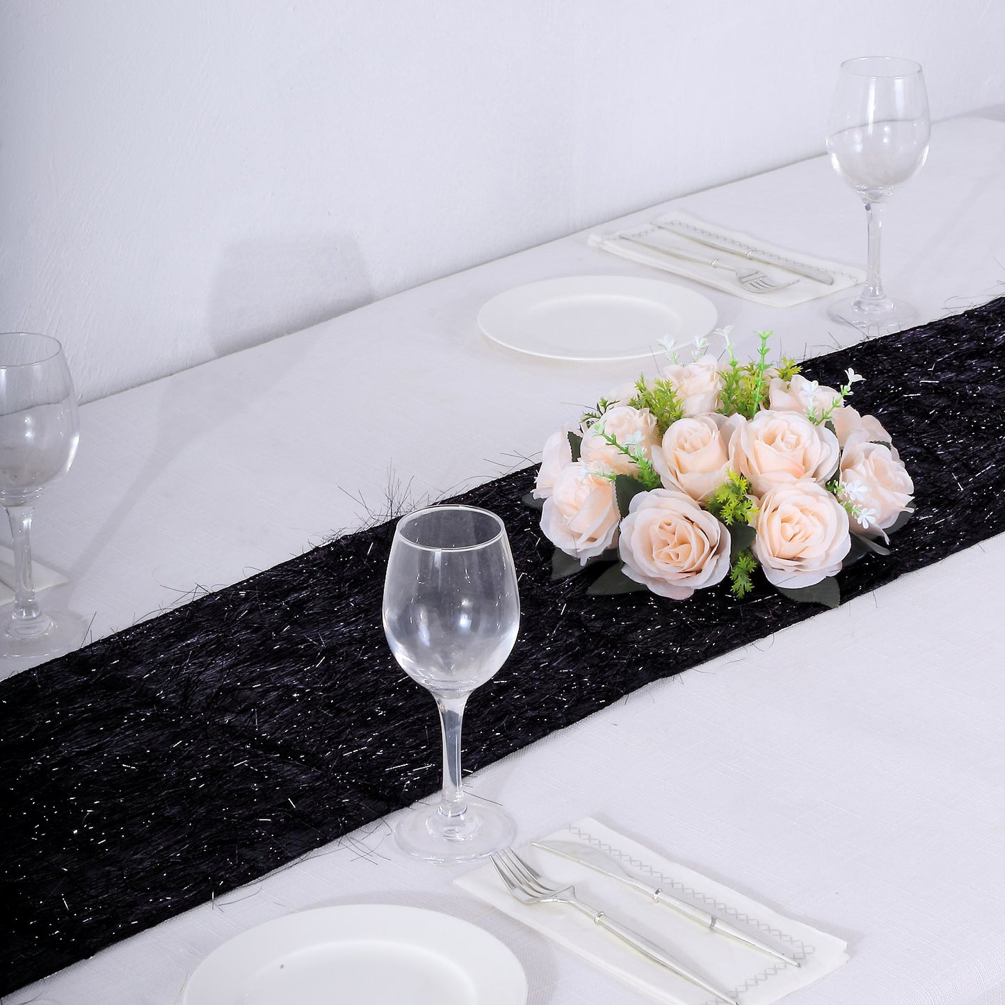 Black metallic fringe table runner with shimmery detail on a dining table.
