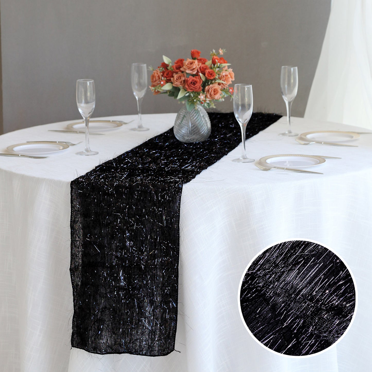 Black metallic fringe tinsel table runner on a white table setting.