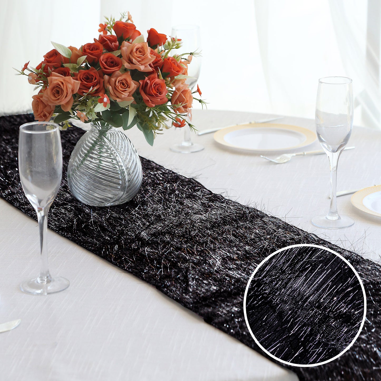 Black metallic fringe tinsel table runner on a dining table with floral centerpiece.