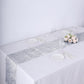 Silver metallic fringe shag tinsel table runner on a white table.