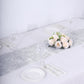 Silver metallic fringed table runner on a white table setting.