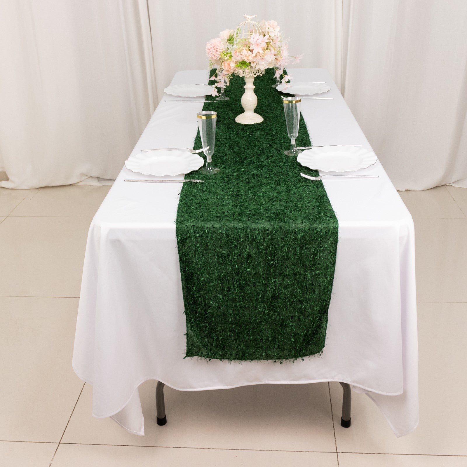 Green shag minky polyester table runner on a white table with floral centerpiece.