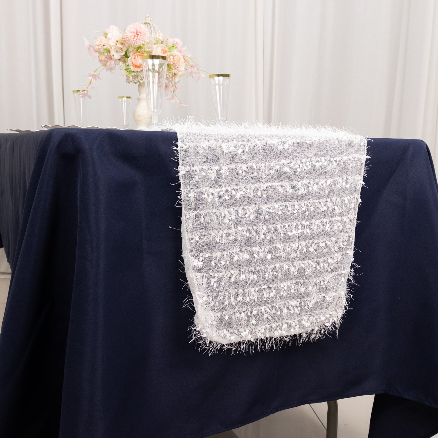 White shag minky polyester table runner on a dark blue table.