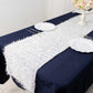 White shag minky polyester table runner on a dark blue table.