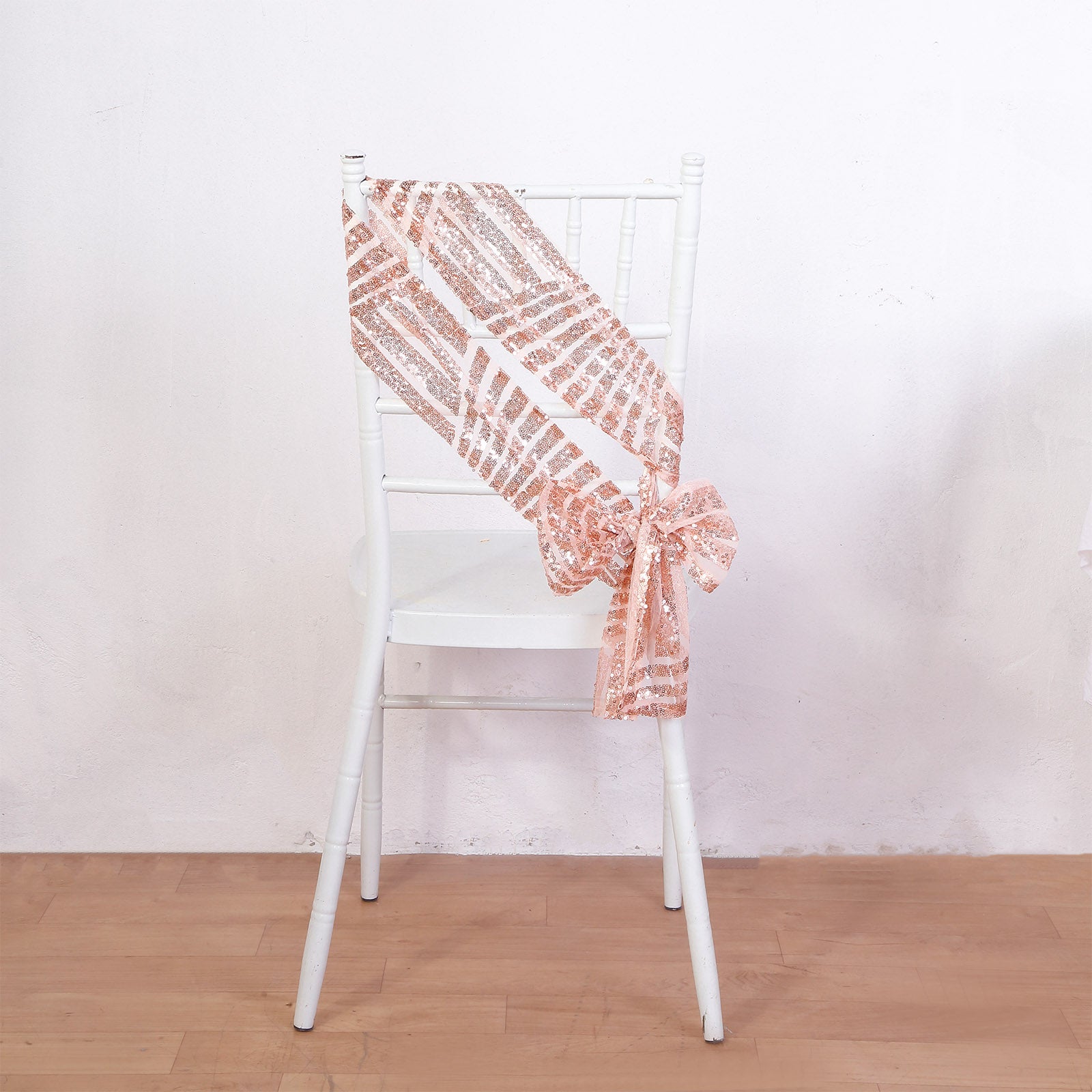 Rose gold geometric diamond sequin chair sash on a white chair.