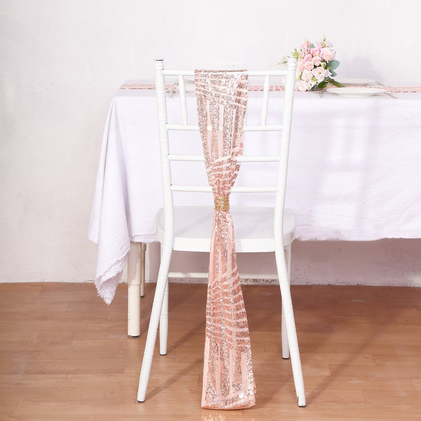Rose gold sequin chair sash on a white chair.