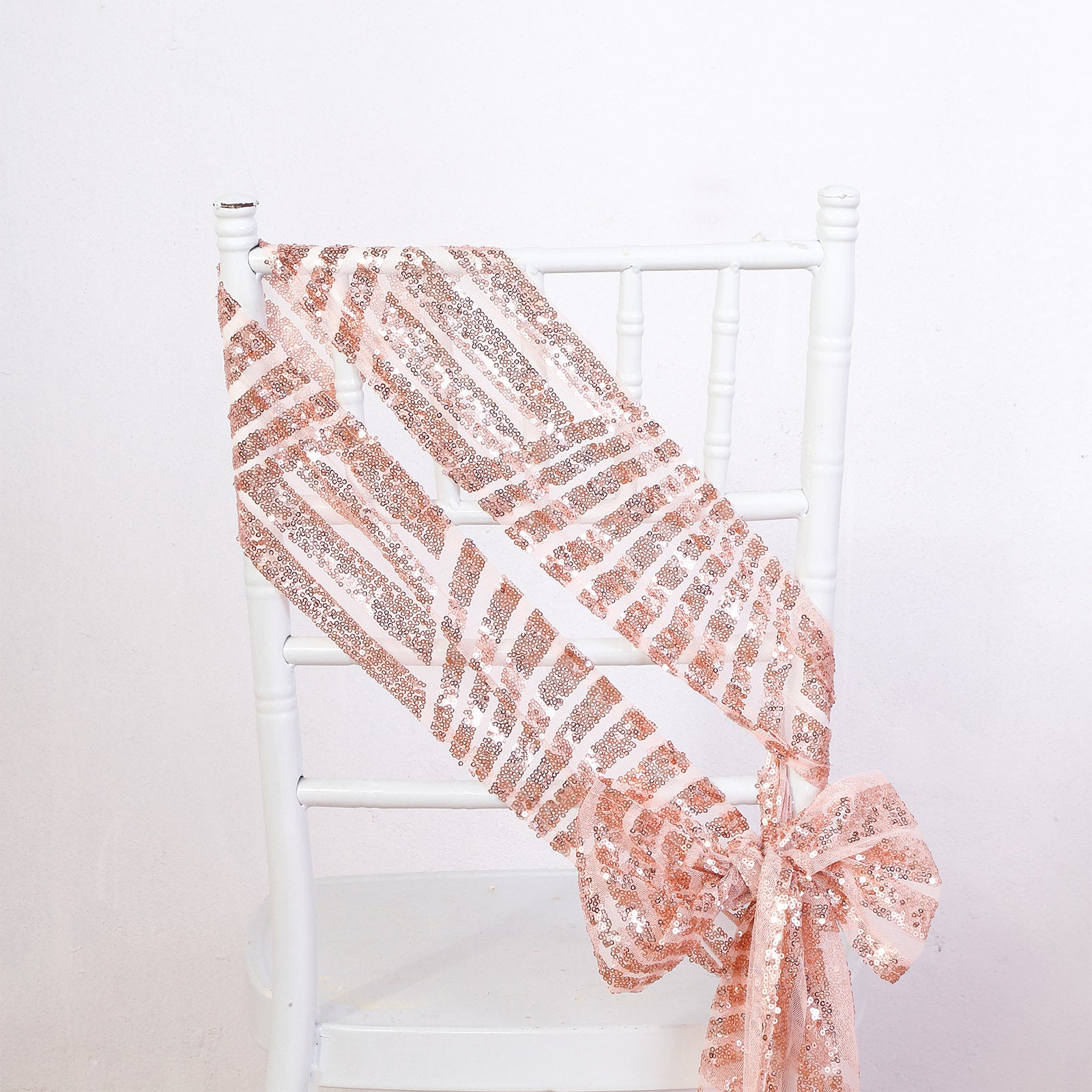 Rose gold geometric diamond glitz sequin chair sash on a white chair.