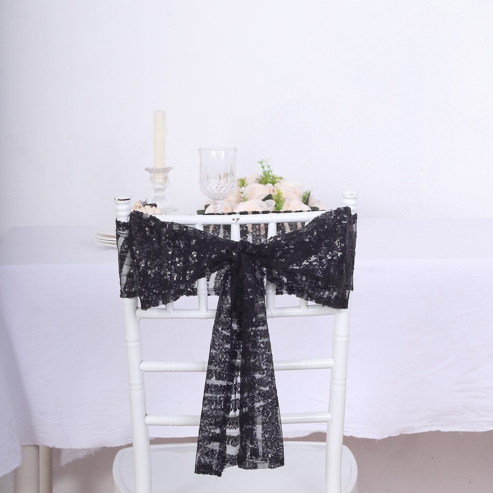 Black geometric diamond glitz sequin chair sash on a white chair.